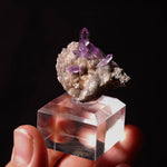 amethist met paarse kleur op een sokkel in hand. vindplaats is Osilo, Sardinië, Italië.