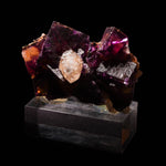 fluoriet met calciet en chalcopyriet op een sokkel.